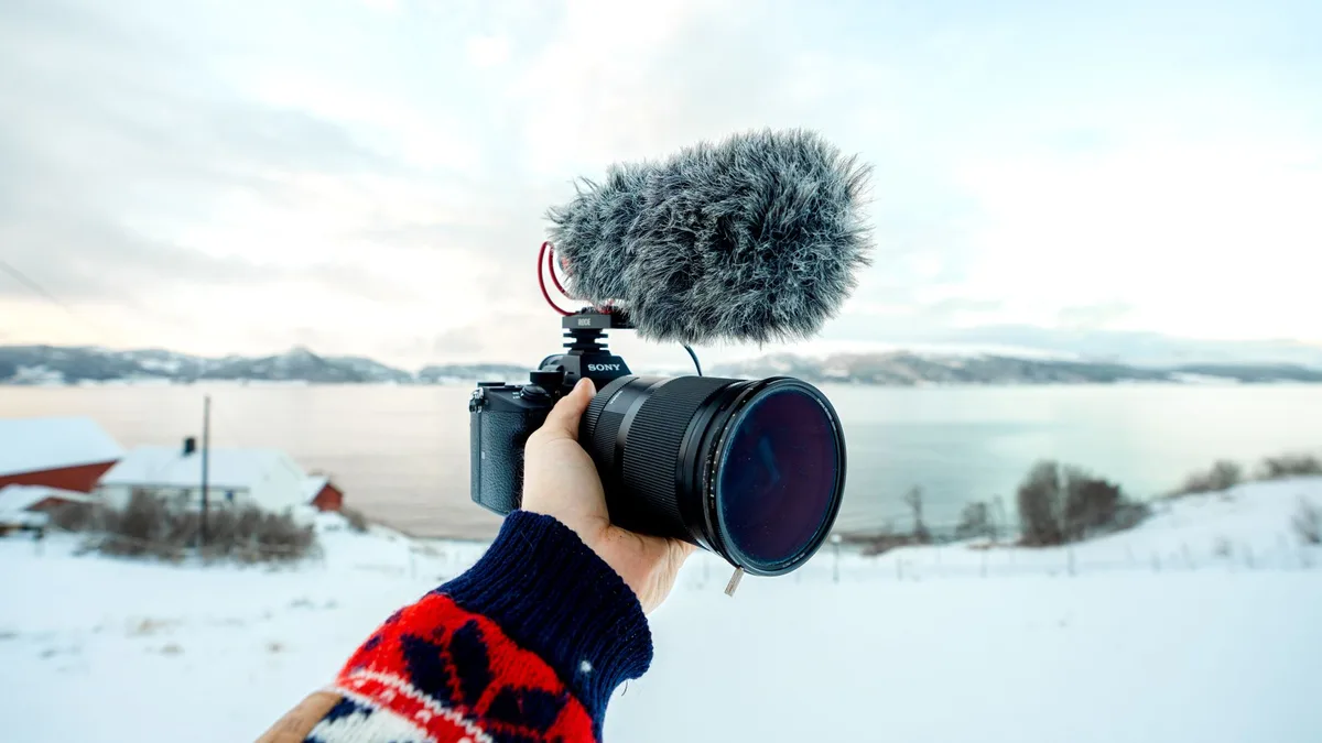 Bir içerik üreticisinin elinde tuttuğu kompakt gimbal kamera ile çekim yapması