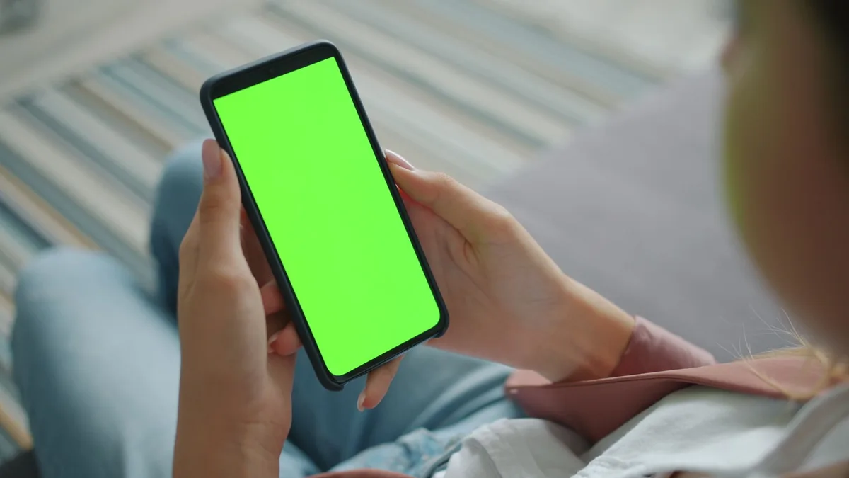 Akıllı telefon kullanan bir kişinin elindeki dijital içerik platformu ekranı