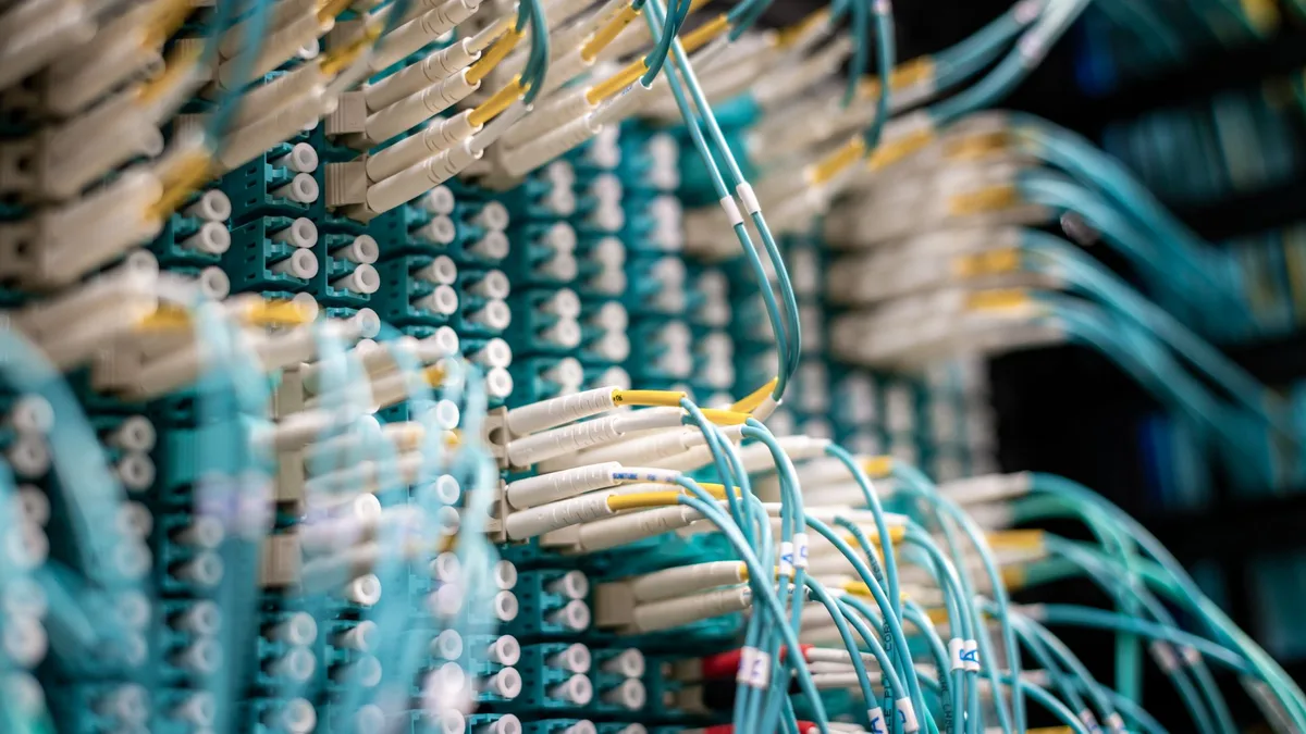 Yakın plan çekimle sergilenen mavi ışıklı fiber optik kablo bağlantı noktaları