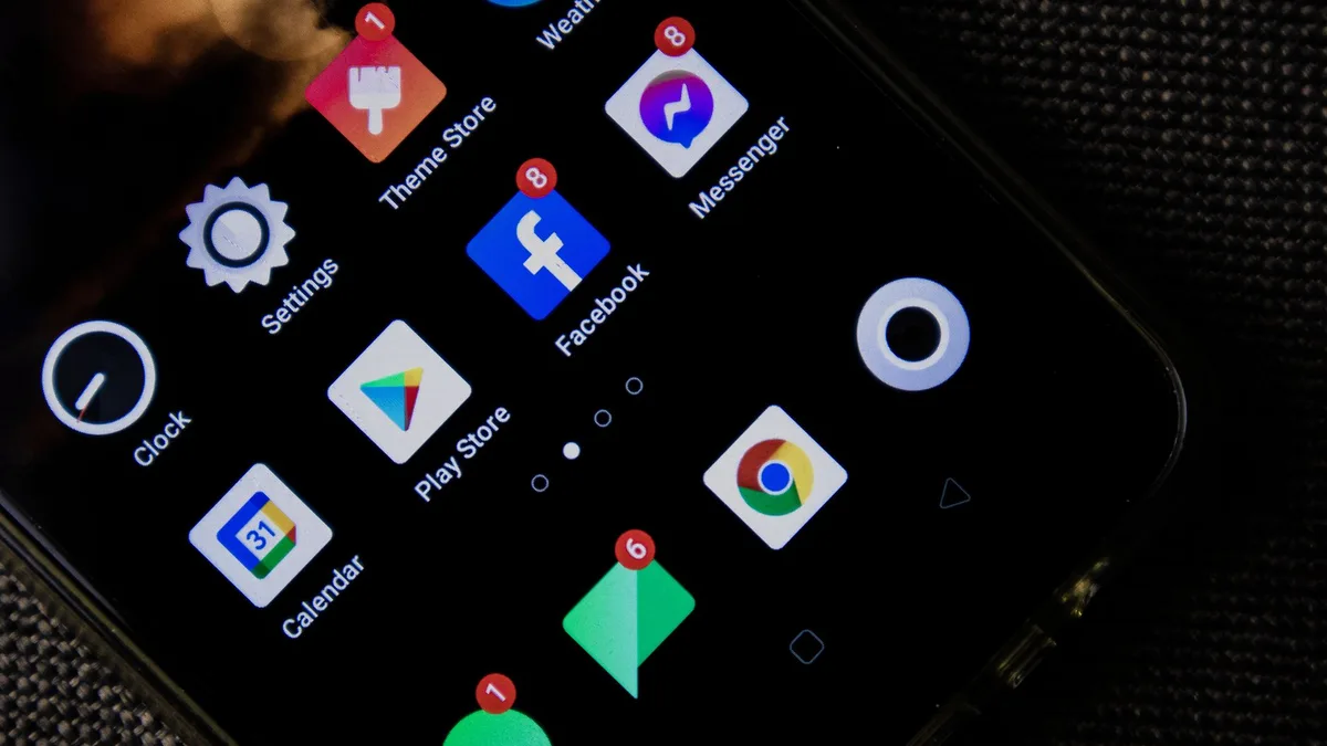 Masaüstünde duran bir Android telefonun ana ekran arayüzü ve uygulama çekmecesi