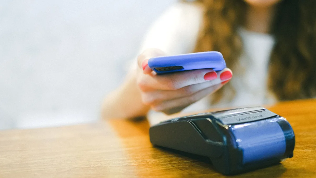 Bir kullanıcının akıllı telefonuna NFC anahtarını yaklaştırarak uygulama kilidini açma anı