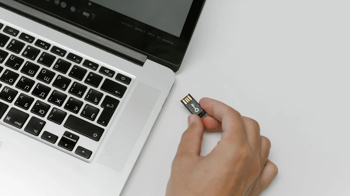 Küçük bir microSD hafıza kartını akıllı telefonun yan girişine yerleştiren kişi