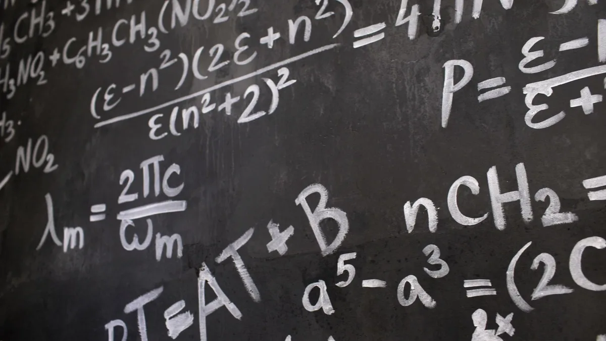 Kara tahta üzerinde karmaşık matematik formülleri inceleyen araştırmacı