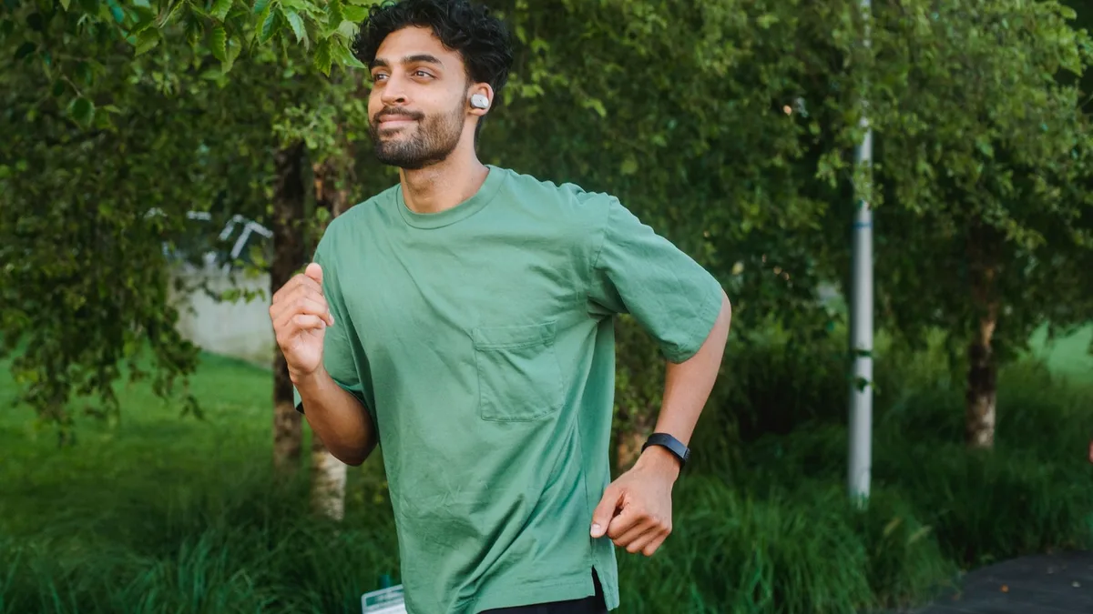 Kablosuz kulaklık takarak koşu yapan bir sporcu
