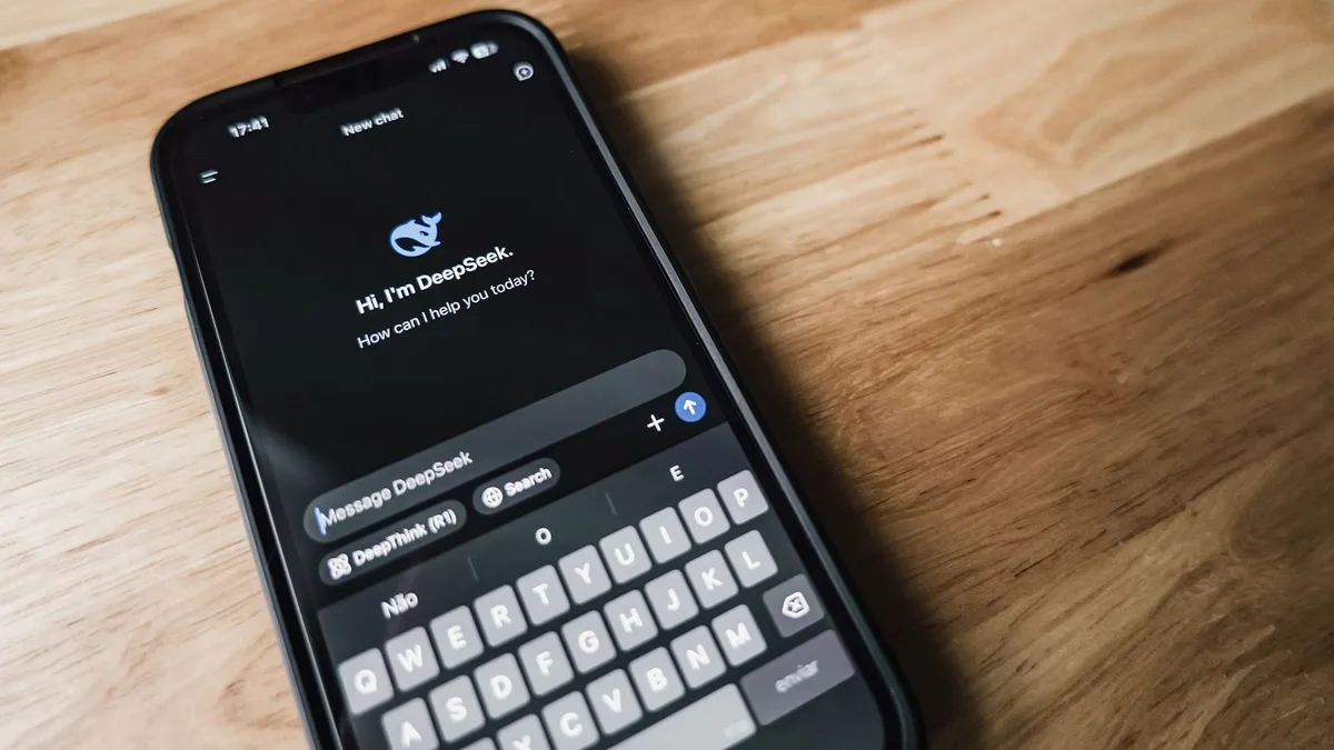 Masada otururken telefonundan sesli asistan kullanan bir kişi