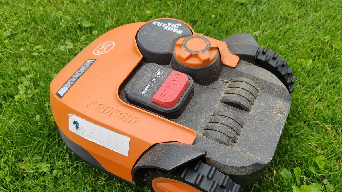 Bahçede çim biçen modern robot çim biçme makinesinin yakından görünümü