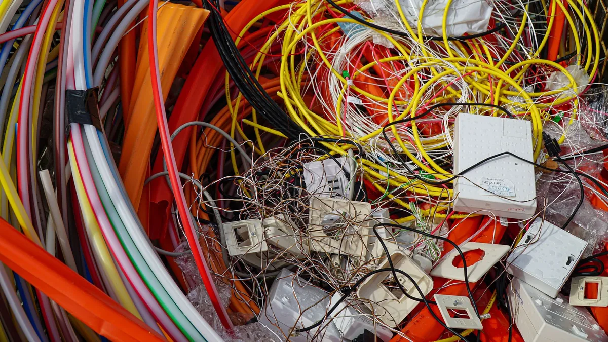 Bir kişinin elektronik kabloları geri dönüşüm kutusuna bırakması