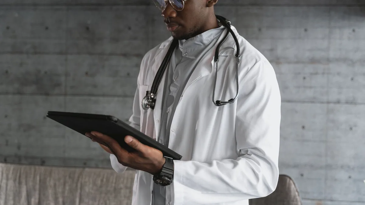 Bir doktor dijital tablet üzerinden hastanın tıbbi geçmişini inceliyor