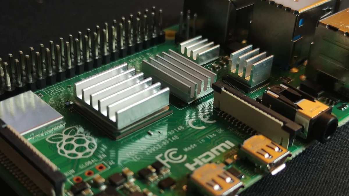 Çalışma masası üzerinde duran çıplak Raspberry Pi 5 anakartı