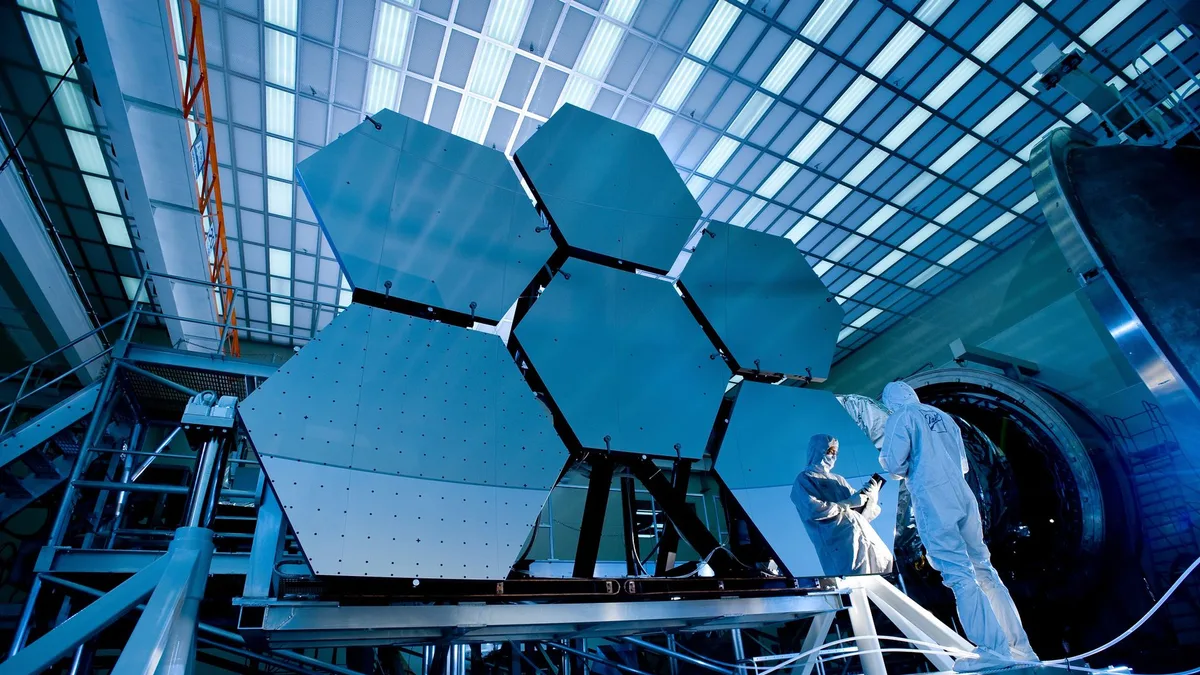 NASA laboratuvarında çalışan bir uzmanın teleskop bileşenlerini incelemesi