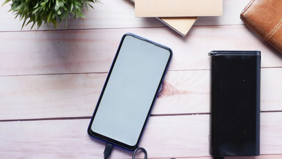 Taşınabilir taşınabilir güç kaynağına bağlı olan telefonu kullanan bir kişi