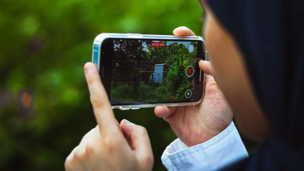 Akıllı telefonuyla dışarıda video kaydı yapan bir içerik üreticisi