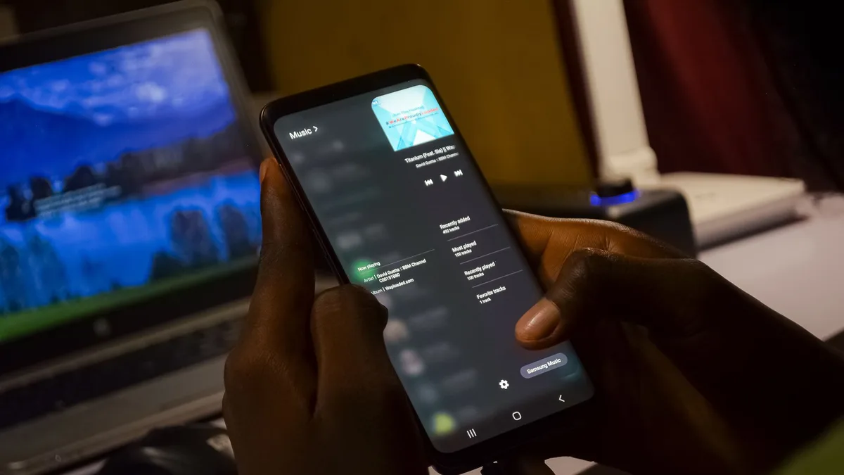 Kullanıcının elinde müzik akış uygulamasını kullanan akıllı telefon
