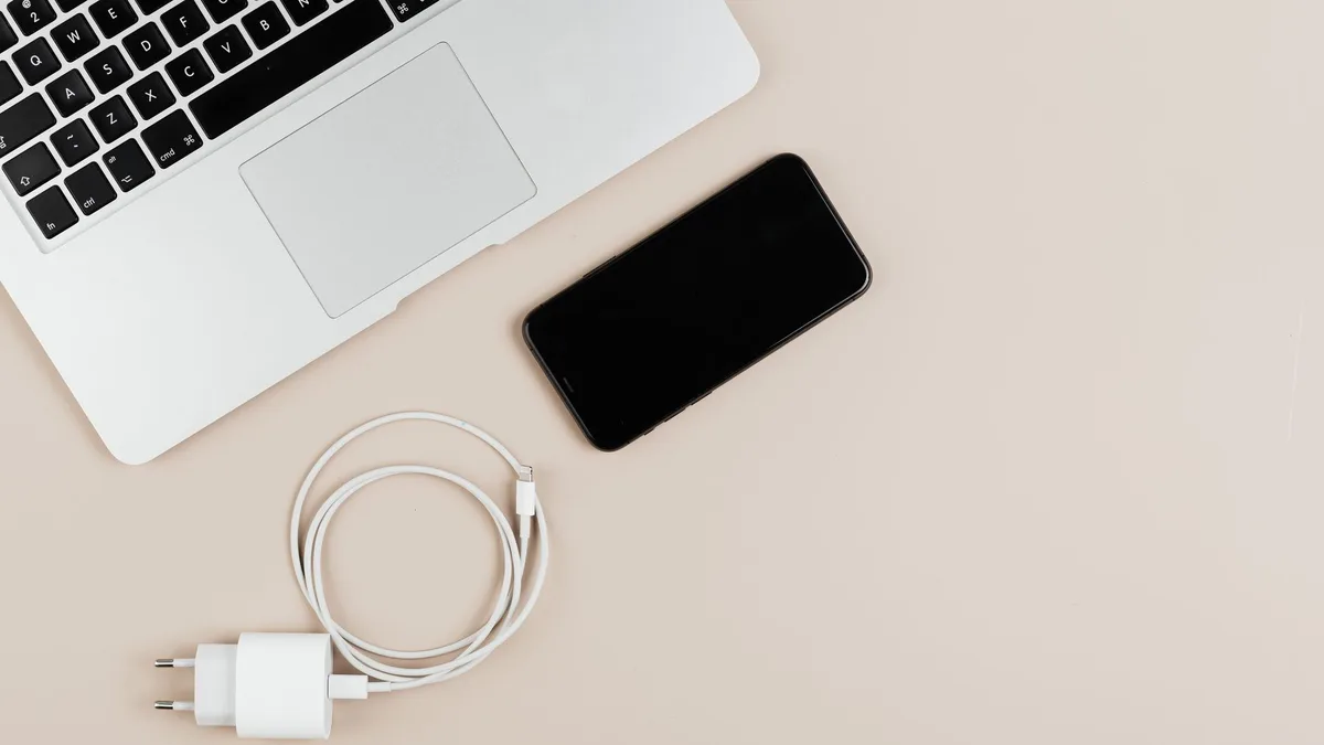 Bir masada bilgisayar ve kablo yardımıyla internet paylaşımı yapan akıllı telefon