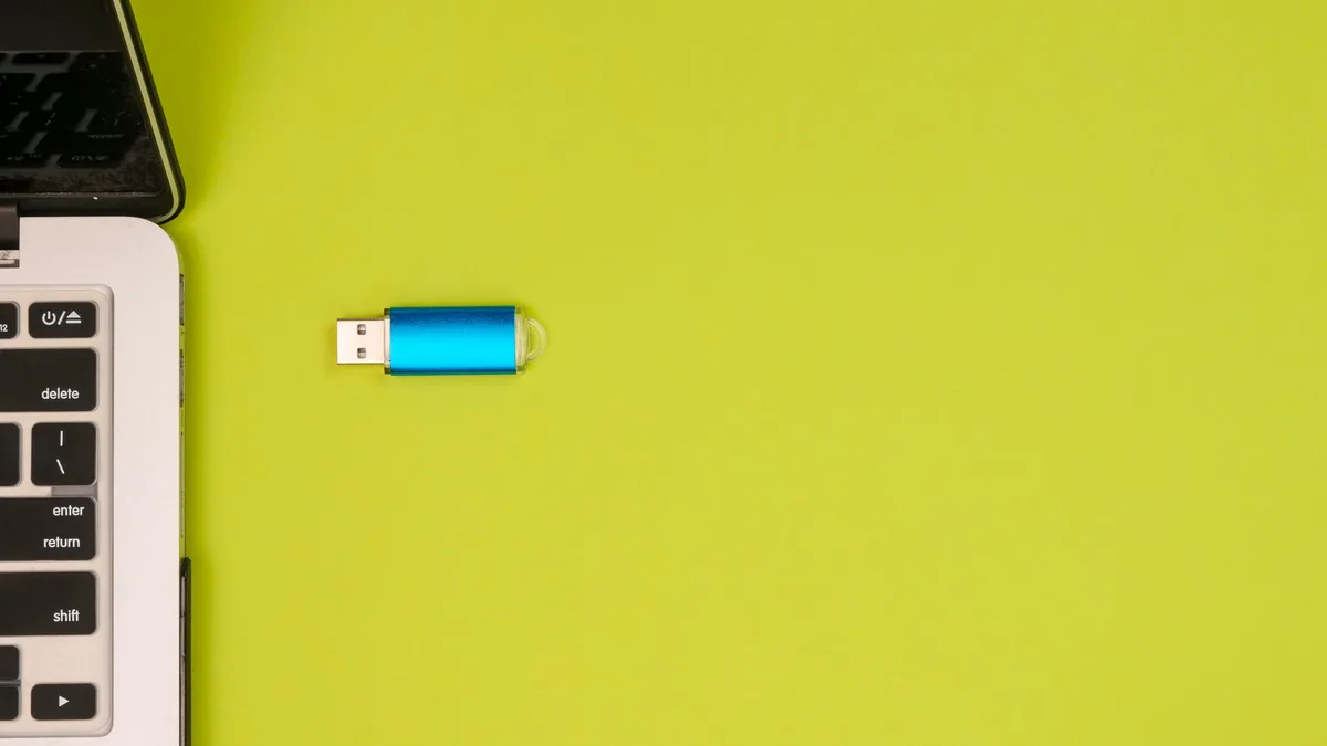 Dizüstü bilgisayarın yan portuna takılmış modern bir USB flash bellek