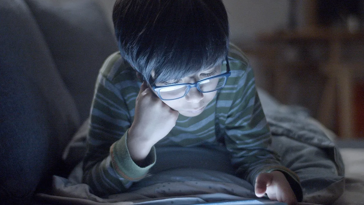 Dijital tablette içerik inceleyen bir çocuğun yakın plan görüntüsü