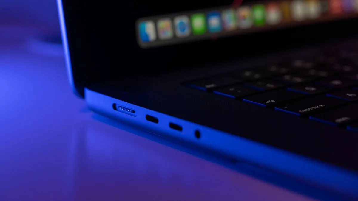 Gövde görseli: USB-C kablosunun MacBook’a takılı olduğu masaüstü çalışma alanı